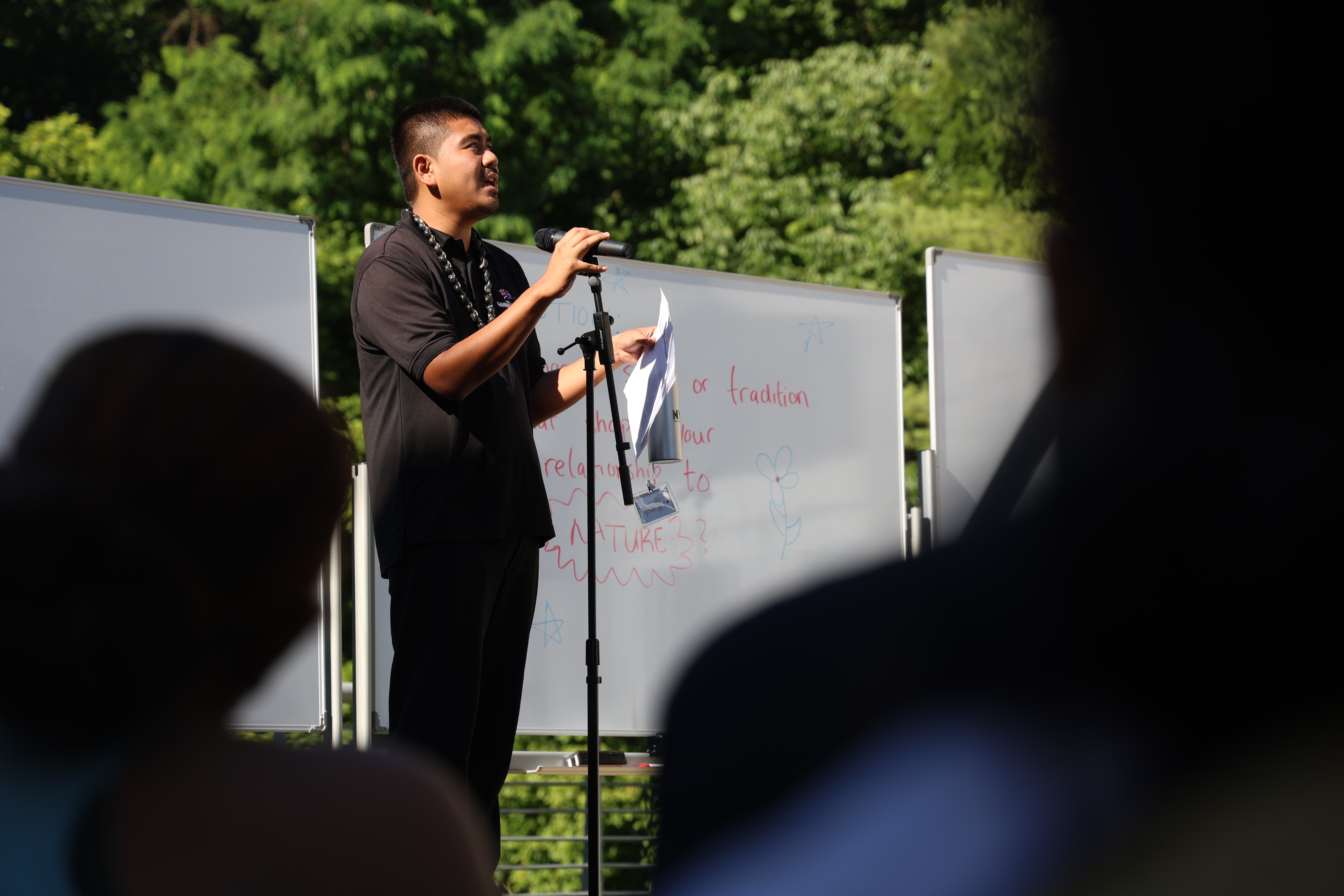 A young person stands at a podium, addressing a crowd